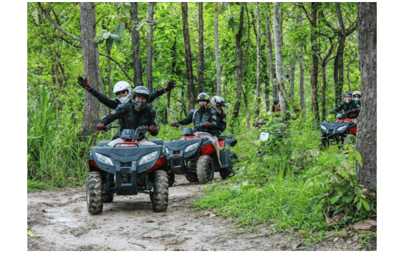 friends riding ATVs in the woods