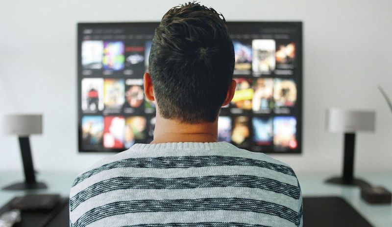Person choosing a movie from their TV