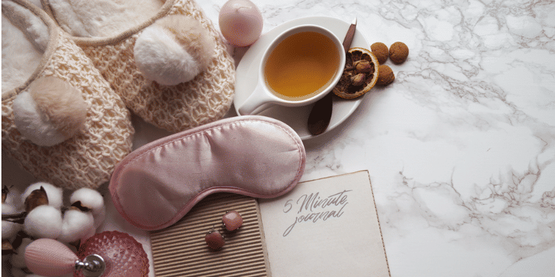 slippers, sleep mask, tea, and journal