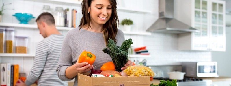 Woman opens Dinnerly box with ingredients inside