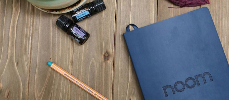 Notebook on table with Noom written on cover