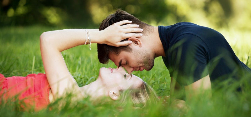 couple touching foreheads in the grass