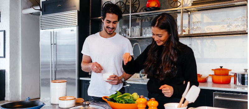 smiling couple cooking together