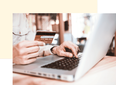 Person holding credit card with open laptop