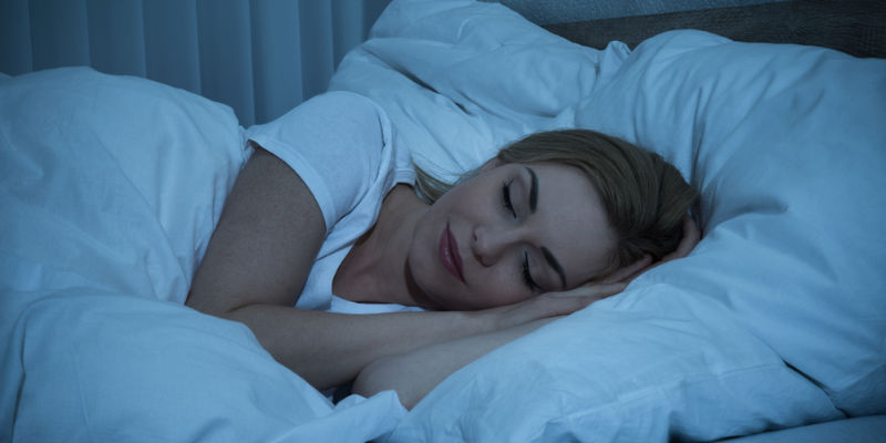 woman happily sleeping in bed