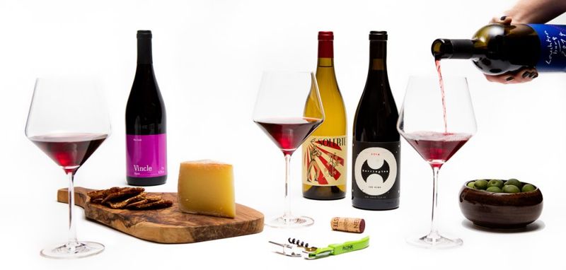 A photo of 3 wine bottles and charcuterie boards