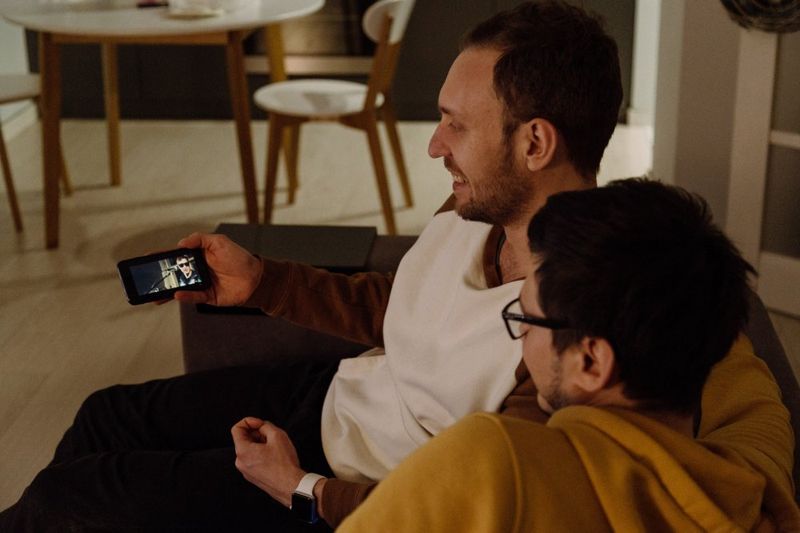 A couple watches TV on their smartphone