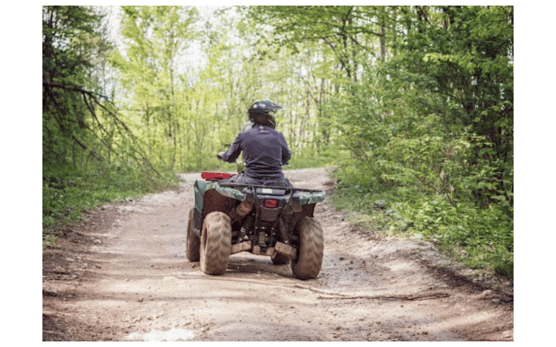 man riding ATV in the woods
