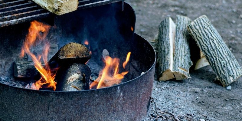 A picture of a fire pit with wood logs nearby