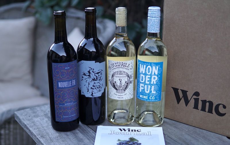 Four bottles lined up side by side, two white wine and two red wine