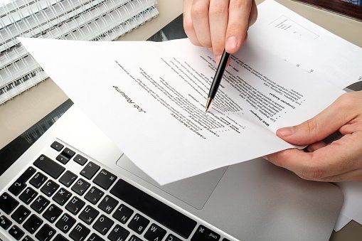Someone looks over a job resume with a pen