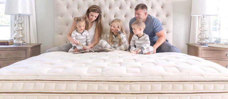 Family of 5 reading a book on a Naturepedic bed