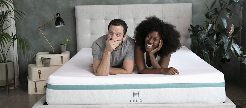A man and woman lying down on a Helix mattress