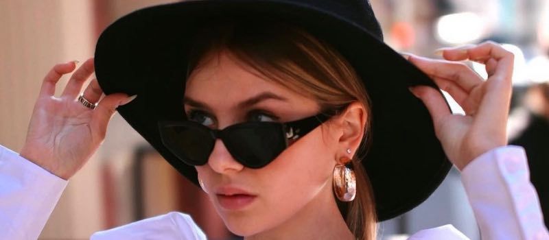 Woman with wide-brimmed hat wearing a pair of Dior sunglasses from Solstice