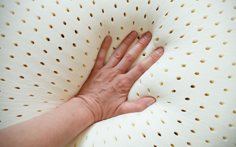 hand pushing down on a mattress