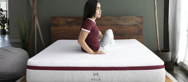 Woman sits on Helix mattress