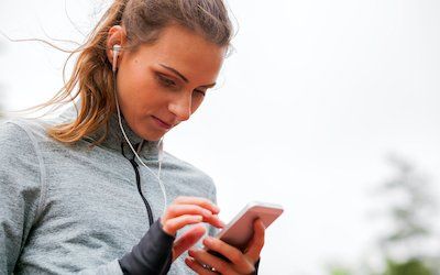 Woman looks at phone before running