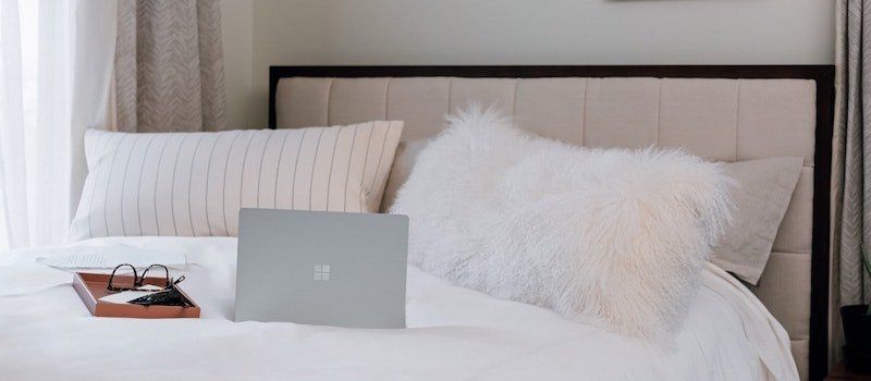 Windows computer on bed next to glasses
