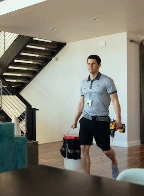 Professional home security installer carries tools in living room