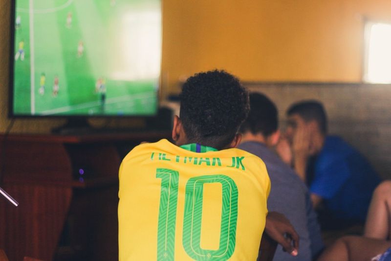 Man with soccer jersey anxiously watching a soccer game
